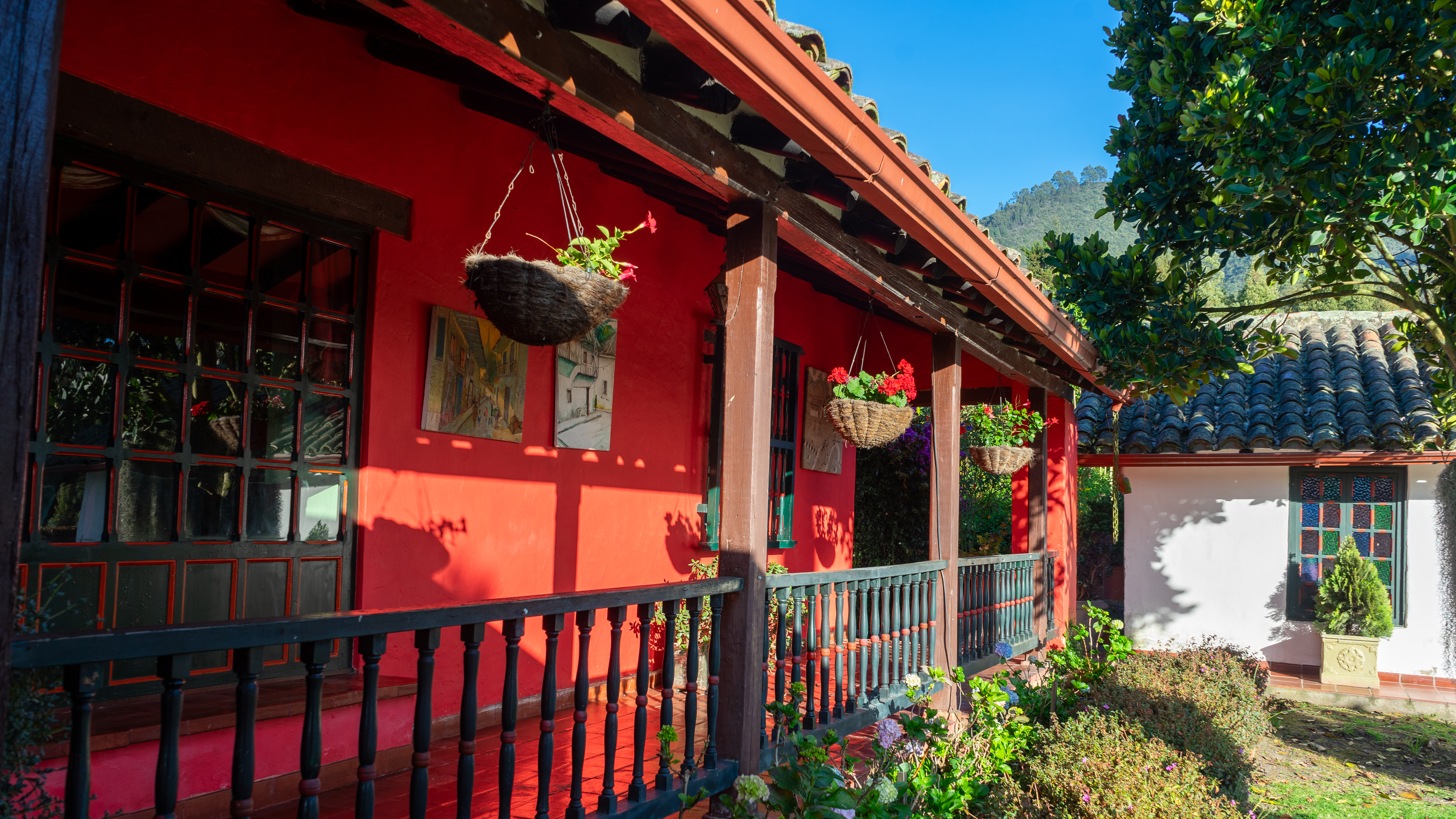 Casa de Cultura Palmarito — fachada roja con jardines y montaña al fondo
